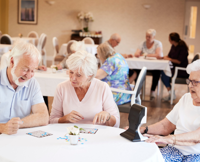 Group Of Seniors Playing Game Of Bingo In Retirement Home