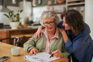 Daughter leaning over mothers shoulder in kitchen